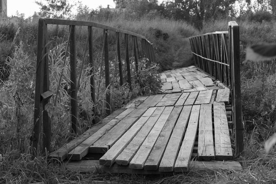 Fototapeta Old terrible bridge over the stream - black and white