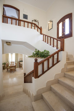 Marble staircase in luxury villa home with wooden bannister