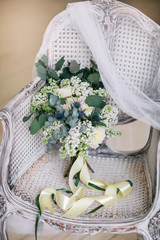 Bride's bouqet on a beautiful classic chair in a white room.