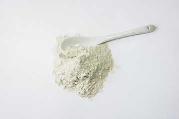 Zeolite raw powder and spoon on white background