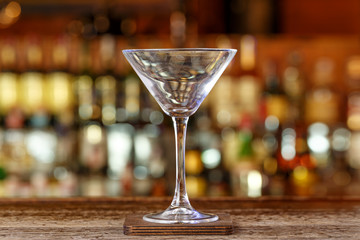 Empty martini glass on the background of the bar