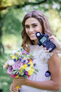 Photographer Measuring Light With Light Meter On Beautiful Girl