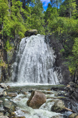 Fototapeta na wymiar Waterfall Corbu in rocks of lakeTeletskoe, Altai Mountains