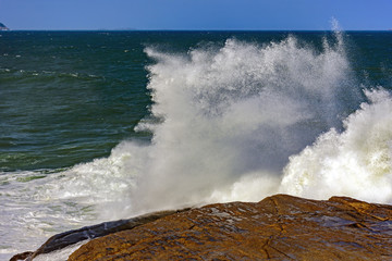 Big, dangerous waves during tropical storm in the green and blue waters of Rio de Janeiro, Brazil