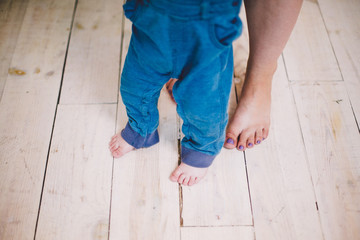 Mother and a son legs on wooden floor