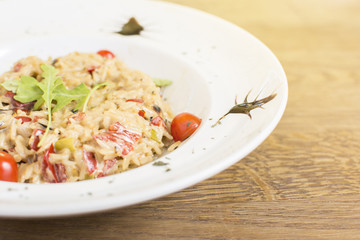 Fragrant Pilau/Pulav / pilaf /pilaf, fried rice with meat and vegetables on a white plate. Isolated on a wooden table.