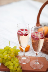 Two glasses of champagne. Picnic on the beach at sunset in the white plaid, food and drink conception