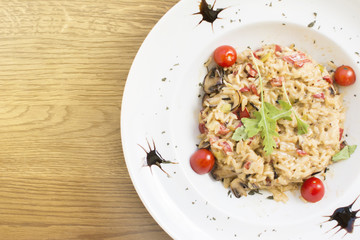 Fragrant Pilau/Pulav / pilaf /pilaf, fried rice with meat and vegetables on a white plate. Isolated on a wooden table.