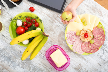 A woman's hand with food and tablet
