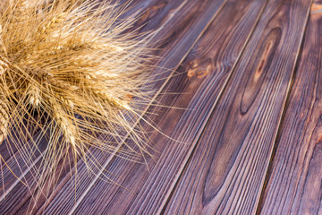 Fototapeta premium ears of wheat on wooden background Harvest concept
