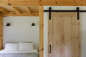 USA, Vermont. Bedroom and bathroom door in a design house. A lot of wooden elements are used in the newly built cabin.