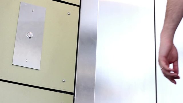 Man pushes the elevator button in modern office building