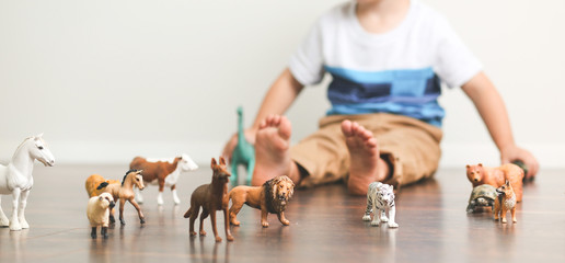 Toddler playing animals versus dinosaurs in bedroom