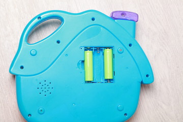 hand the child put the batteries in the blue toy