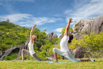 couple making yoga in low lunge pose outdoors