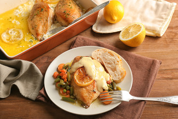 Delicious chicken breast with lemon and vegetables on plate