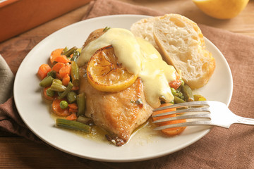 Delicious chicken breast with lemon and vegetables on plate
