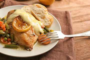 Delicious chicken breast with lemon and vegetables on plate