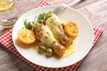 Delicious chicken legs with lemon on plate