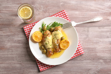 Delicious chicken legs with lemon on wooden table
