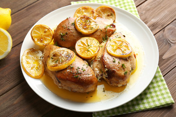 Delicious chicken breasts with lemon on plate