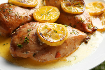 Delicious chicken breasts with lemon on plate, closeup