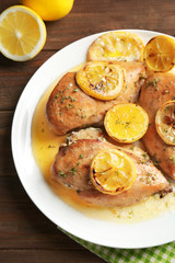 Delicious chicken breasts with lemon on plate