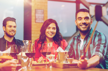 friends taking selfie by smartphone at restaurant