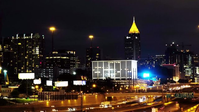 Atlanta, USA. Aerial view of Midtown in Atlanta, USA at night. Highway with cars, illuminated buildings and dark sky