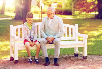 grandfather and grandson talking at summer park