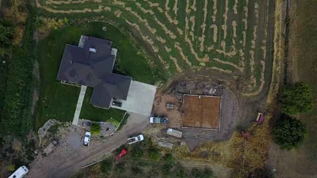 Aerial descend modern farm home new construction. Rural farm agriculture building. Engineering architectural design. Modern facility for farming income. Protection of equipment. and repairs.