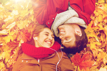 close up of smiling couple lying in autumn park