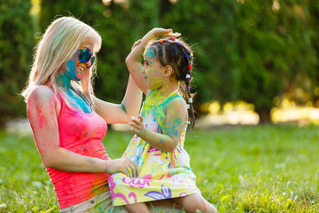 Portrait of happy mother with little daughter on holi color festival