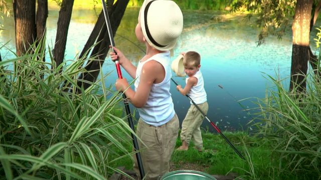 Children fish on the bank of a pond. Children fish on the bank of a pond.
