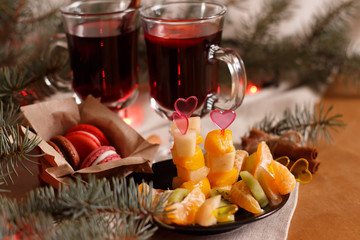 Christmas mulled wine with fruit, canapés and macaroons with fir branches
