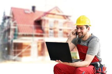 Hausbau - Handwerker bei der Planung mit Notebook und Telefon // House construction - craftsman planning with notebook and telephone