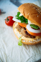 Two hamburgers with beef burger cutlet, fried onion, spinach, ketchup sauce and blue cheese in traditional buns, served on wood chopping board over bright turquoise background. Copy space