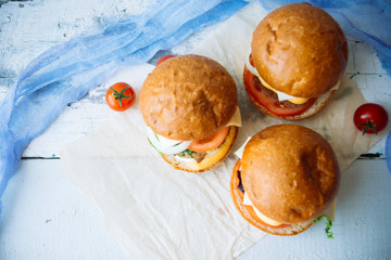 Tasty turkey burgers with corn salad and carrot,mixed seeds served on old board on a rustic wooden table with copyspace.