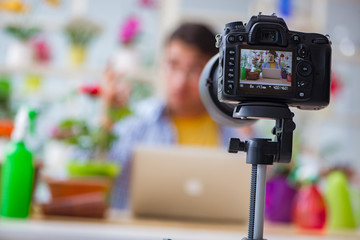 Man florist gardener vlogger blogger shooting video on camera