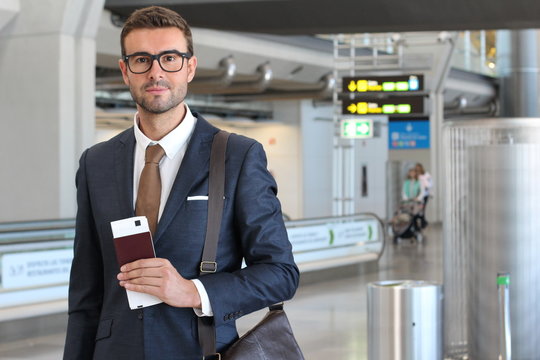 Businessman holding passport and boarding pass at the airport