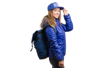 Beautiful young girl in a jacket with a cap and backpack