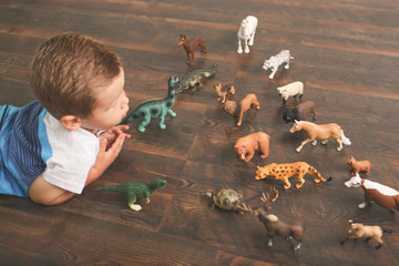 Naklejka premium Lifestyle of little boy playing with animal action figures