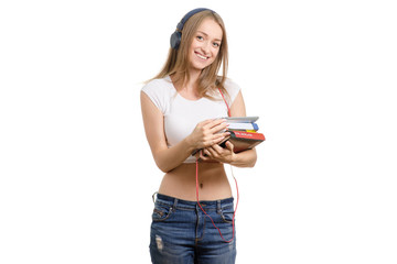 Beautiful young girl with books and tablet on headphones