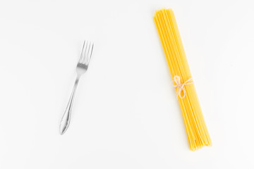 Fork With Raw Italian Spaghetti Pasta On White Background Closeup
