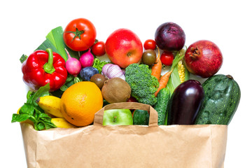 Full paper bag of different fruits and vegetables on a white background