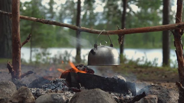 camping teapot over fire medium shot