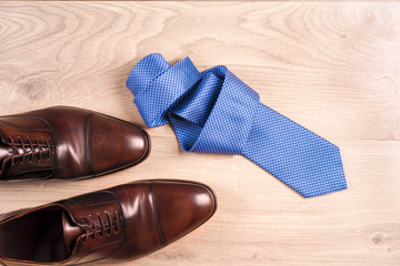 Men's accessories men's shoes, tie on a wooden background. Classic men's accessories. Top view