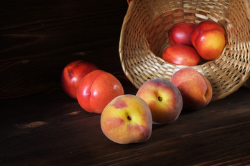 Two mature peaches on a wooden background