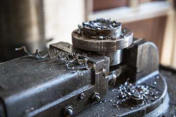 Drill close up - Close up drill tool in chuck during metal cutting process hole boring in iron piece at industrial factory workshop