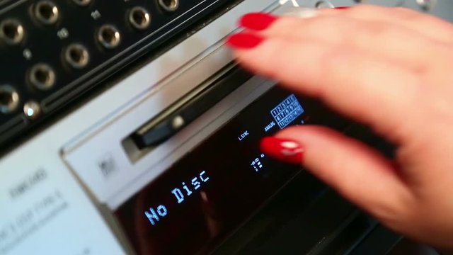 The female right hand presses the eject mini disc recorder button, the display lights up No Disc